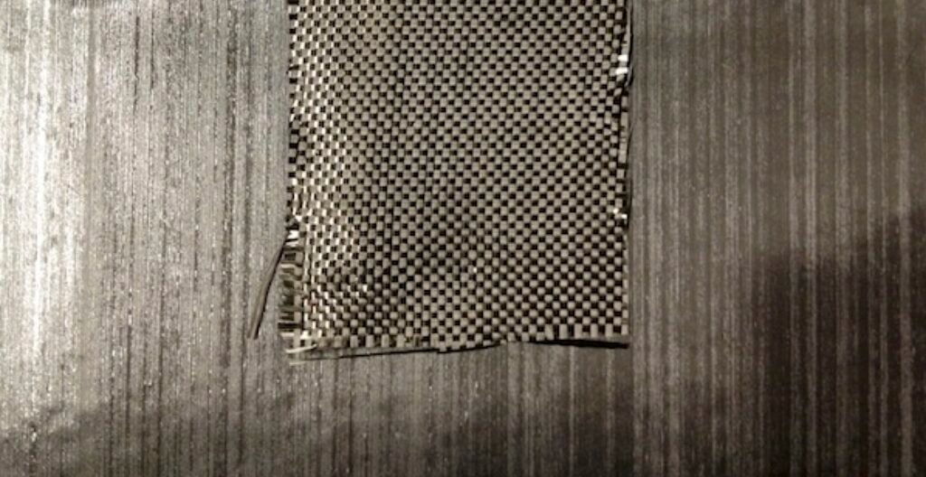 Unidirectional carbon fiber with woven carbon fiber on top of it