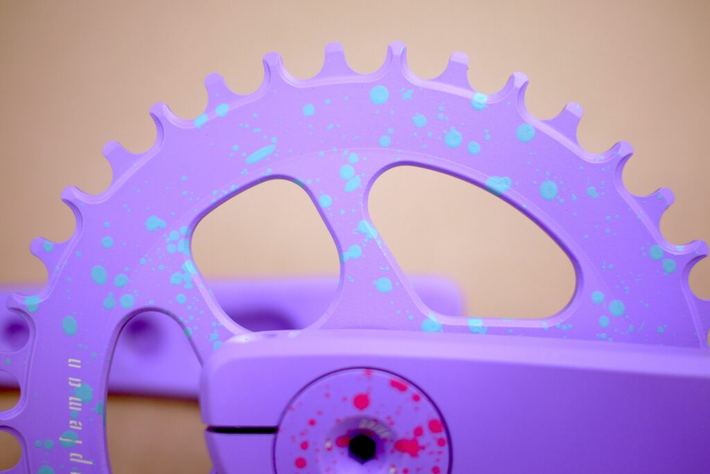 close up of 2XR crankset lavender splatter turquoise pink